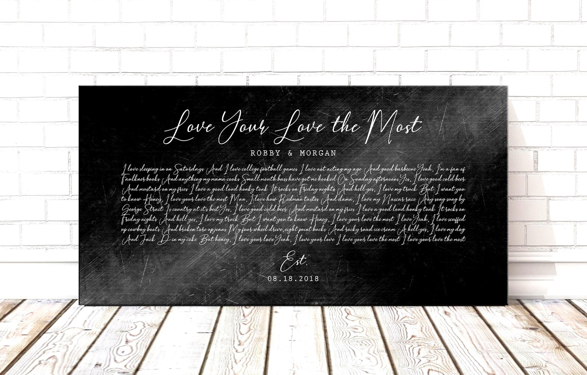 Black distressed metal song lyric art, personalized lyrics plaque on iron alloy displayed on wood plank floor.