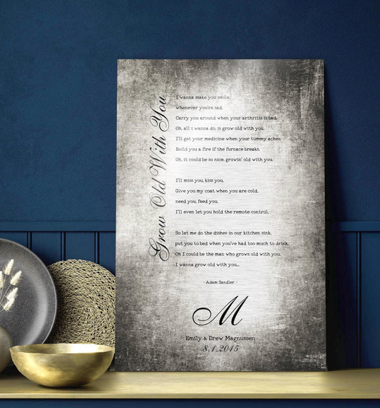 Couples custom song lyrics wall decor - vintage metal tin aluminum song plaque sits on a navy background on a counter top. The sign features the inscription “Grow Old With You” in an elegant calligraphy running vertically up the side of song lyrics in a stanza format - which is an except from the lyrics. Beneath is a last name Monogram letter, names and a union date, for posterity.    Photo courtesy of Honeycomb Proverbs
