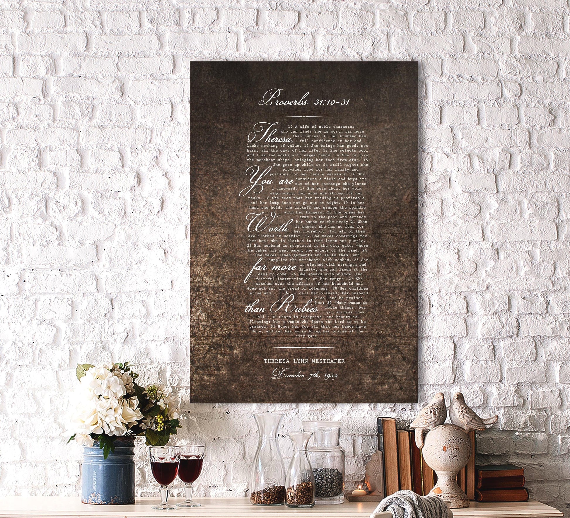 A rustic and romantic burnished metal plaque hangs on a brick wall above a desktop with 2 wine glasses and a bird statue. The Plaque reads, Theresa you are more precious than rubies, and is personalized with her name. A dedication note is beneath the bible verse.

Christian wall art Photo Courtesy of Honeycomb Proverbs