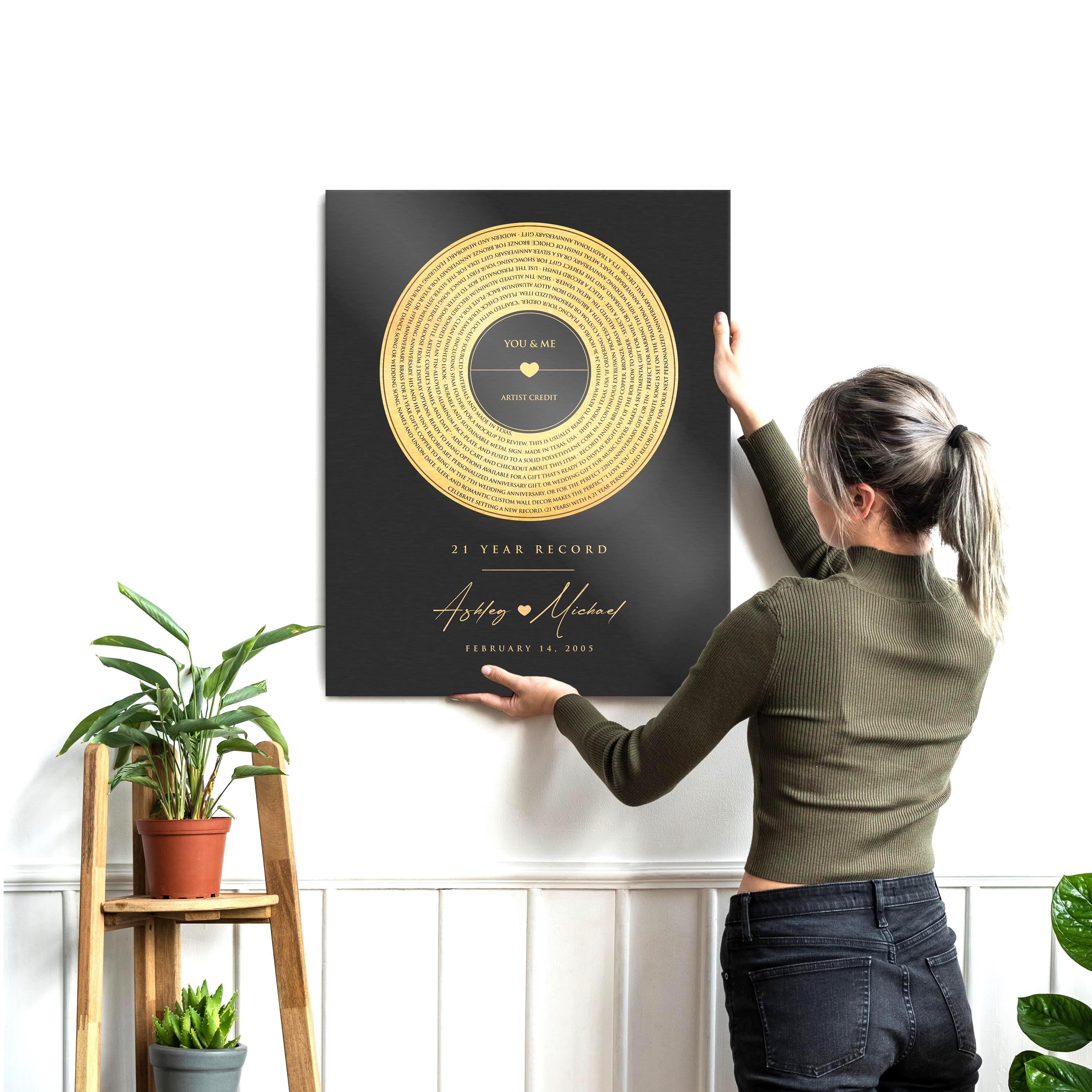 Brass vinyl metal record art with a brass record motif and custom song lyrics with the phrase "21 Year Record", names Ashley and Michael with a heart between them, and a wedding date below.